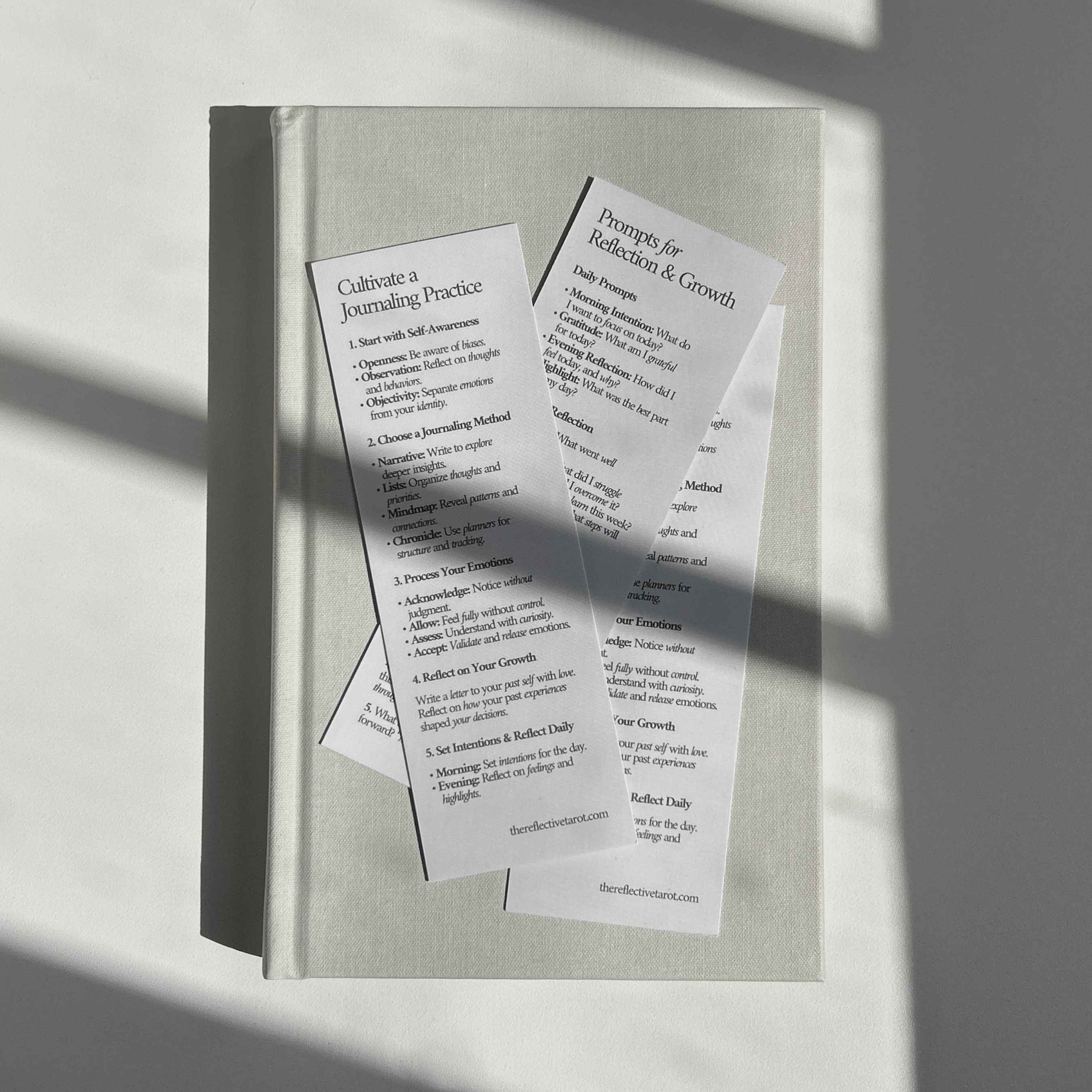 Set of bookmarks on a journal, featuring 'Cultivate a Journaling Practice' and 'Prompts for Reflection & Growth,' offering guidance for reflection, journaling, and personal development.