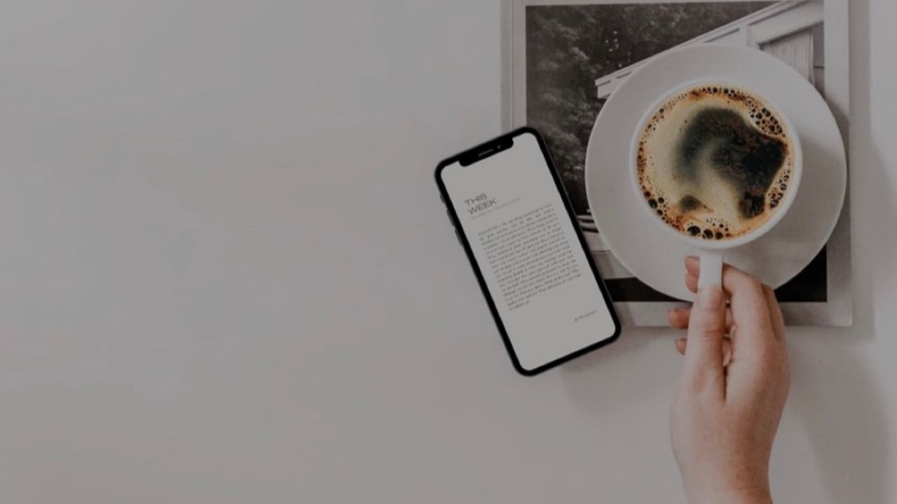 A lifestyle flat lay image featuring a smartphone displaying a newsletter, a coffee cup, and a magazine. Perfect for illustrating a relaxing moment of reading digital content with coffee.